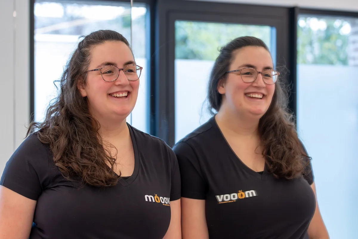 Natasja Cool lacht samen met een collega in de trainingsruimte van MOOOV
